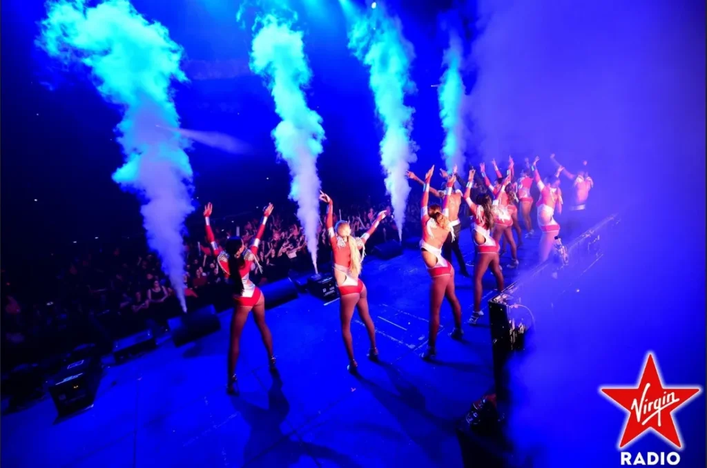 Étincelles froides sur scène derrière des danseurs, lors d’un événement Virgin Radio