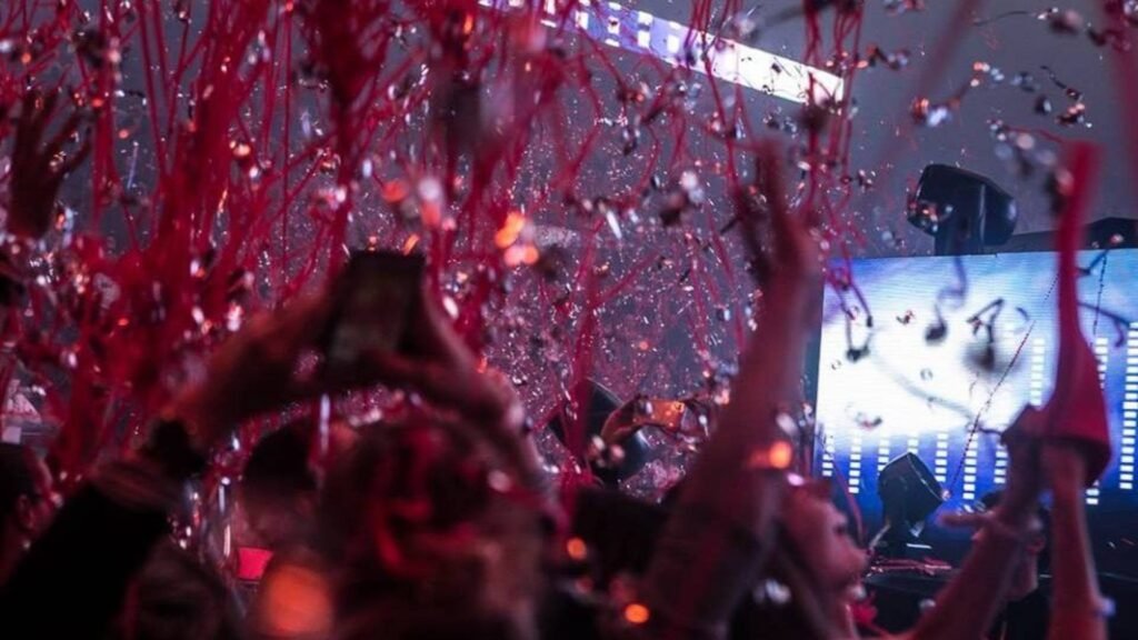 Serpentins rouges retombant sur un public en fête