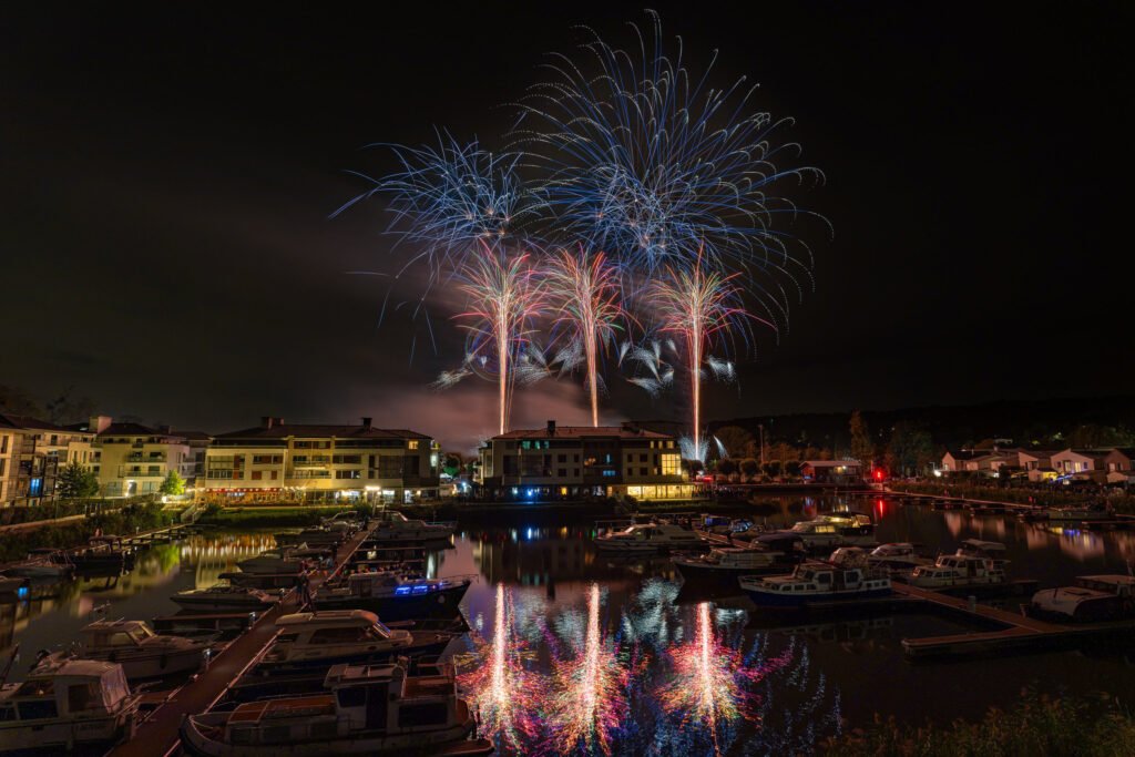 Bombes bleues et chandelles au-dessus de la Marina de L’Isle-Adam, reflets dans le port