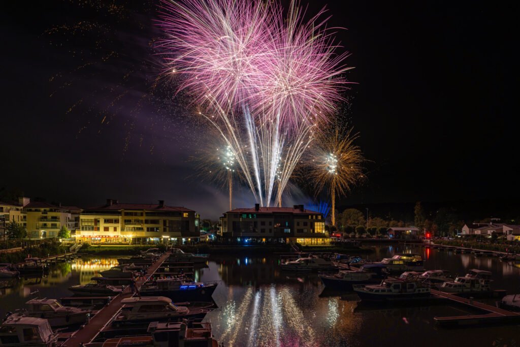 Bombes roses au-dessus de la Marina de L’Isle-Adam, bateaux amarrés au premier plan