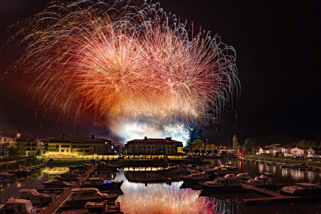 Bombes rouges et or au-dessus de la Marina de L’Isle-Adam, reflets dans le port