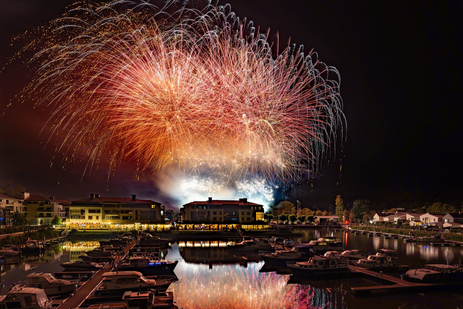 Bombes rouges et or au-dessus de la Marina de L’Isle-Adam, reflets dans le port